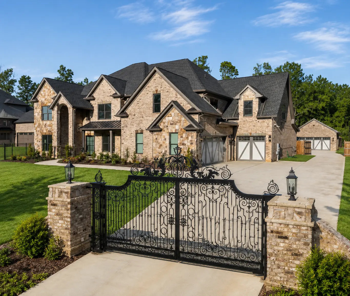 Custom metal driveway gate in front of an estate home in Ontario, Canada